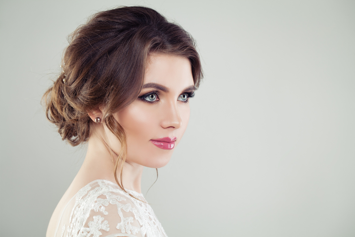Beautiful female face. Young perfect woman with makeup and bridal hairdo